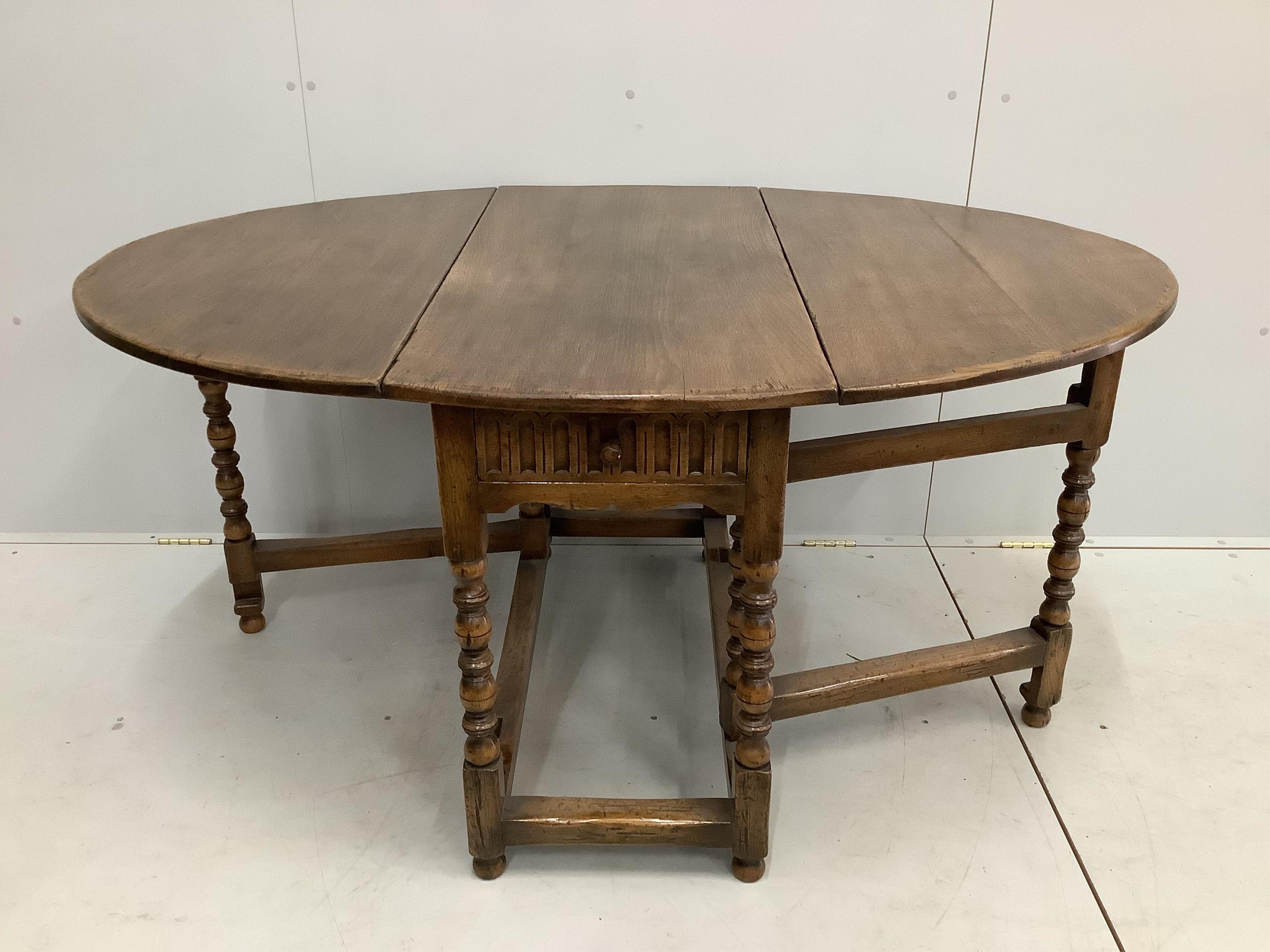 A reproduction 18th century style oak gateleg dining table, width 106cm, depth 50cm, height 73cm